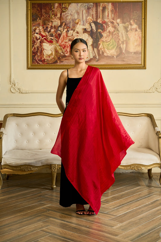 Bright red hand-dyed mulberry silk scarf draped over a black velvet evening dress