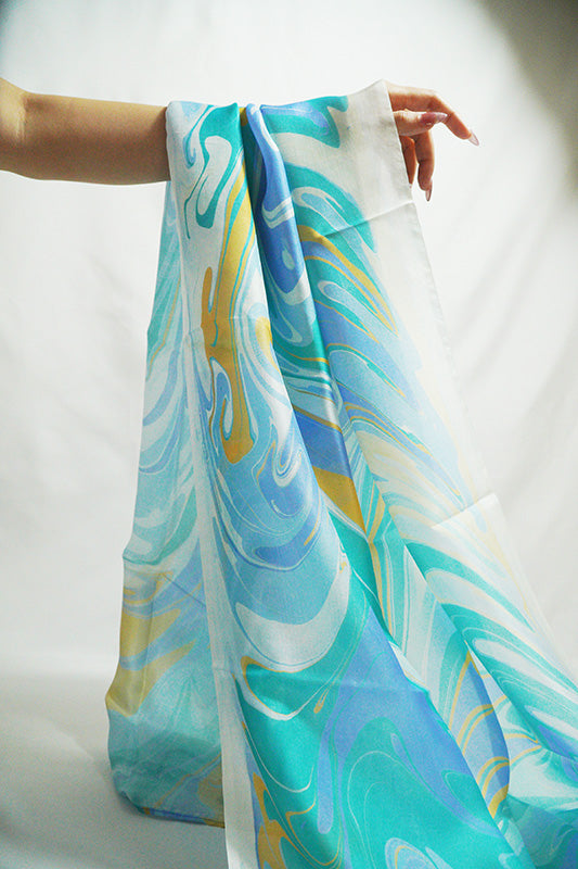 Marbled peacock blue silk scarf worn as a flowing shawl, hand-dyed mulberry silk