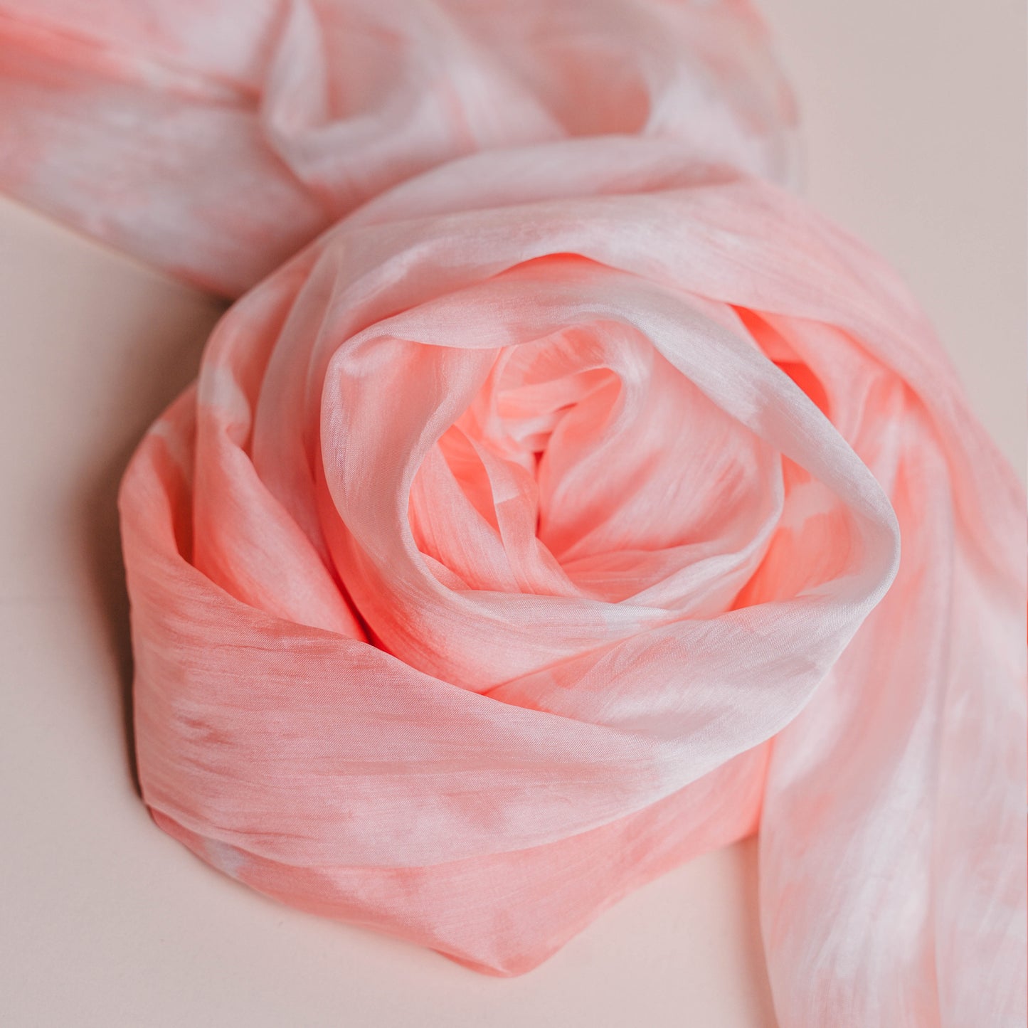 Peach orange shibori silk scarf held open to show the full pattern