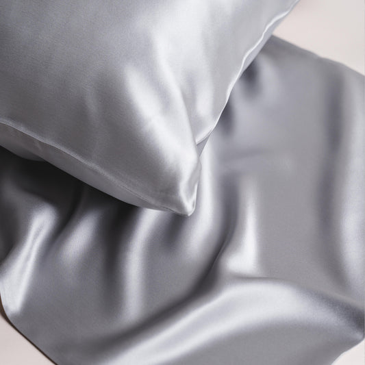 Silver mulberry silk pillowcase styled on a bed