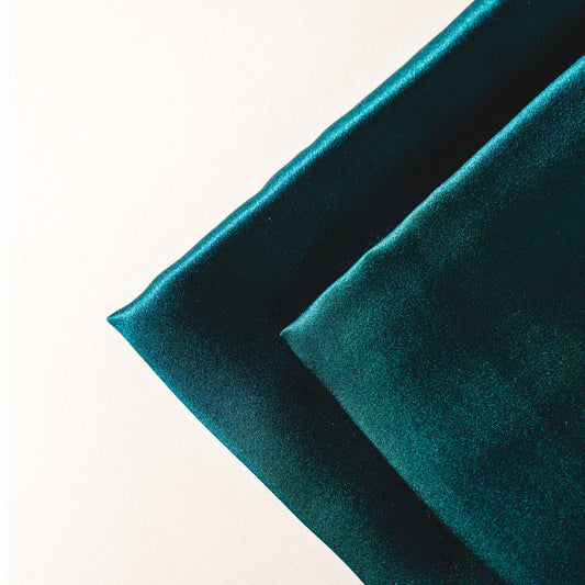 Green mulberry silk pillowcase styled on a bed