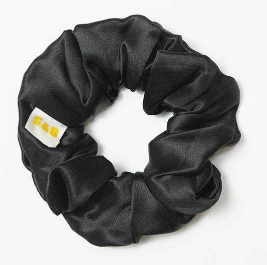 Large mixed-colour silk scrunchies worn in the hair