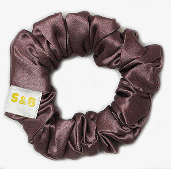 Medium dark peach silk scrunchies worn in the hair