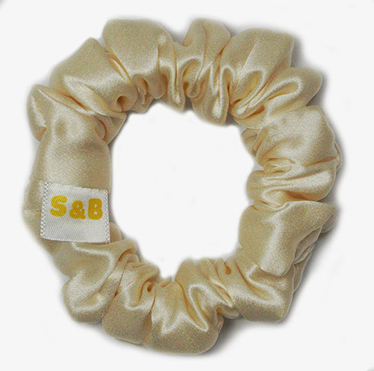 Medium light gold silk scrunchies worn in the hair