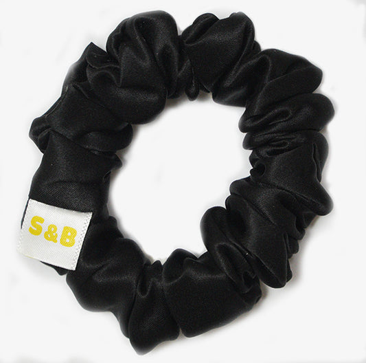 Medium black silk scrunchies worn in the hair
