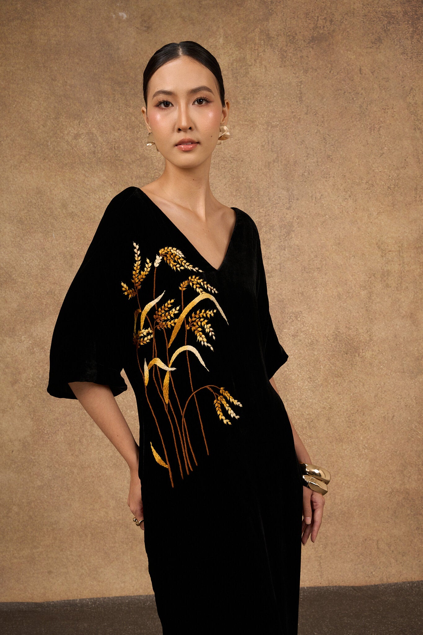 Editorial three-quarter view of the black and gold silk velvet dress