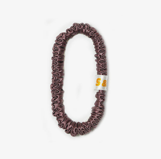 Skinny dark peach silk scrunchies worn in the hair