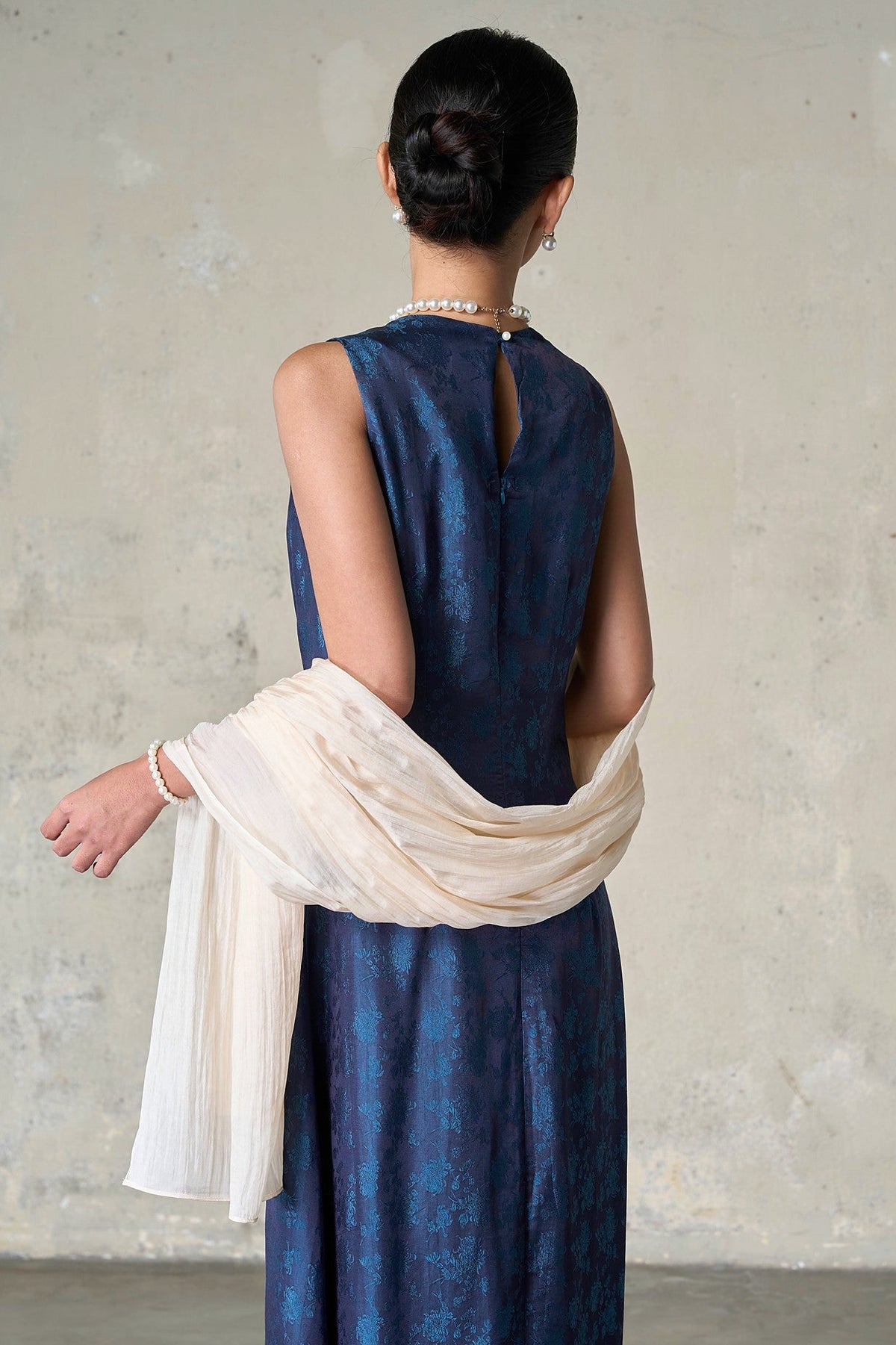 Back view of the champagne silk scarf wrapped around the shoulders and falling at the side