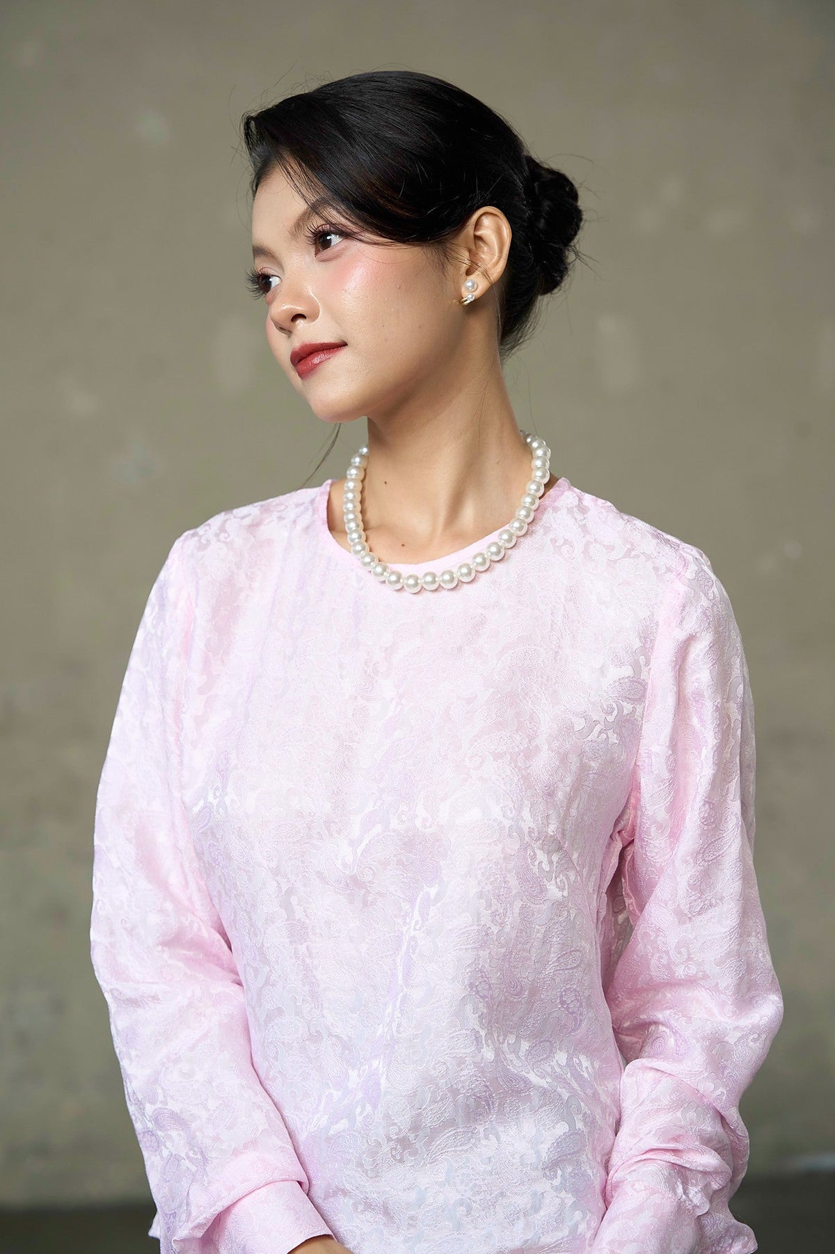 Close-up of blush pink silk blouse showing tonal paisley jacquard, round neckline and full sleeve