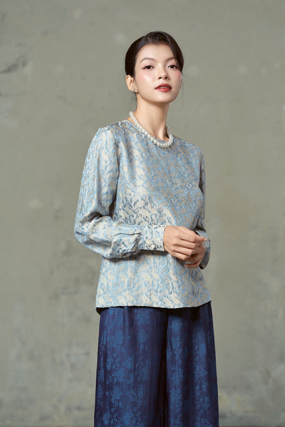 Model in blue and gold paisley silk jacquard blouse with full sleeves, Rosalind Delft Gold