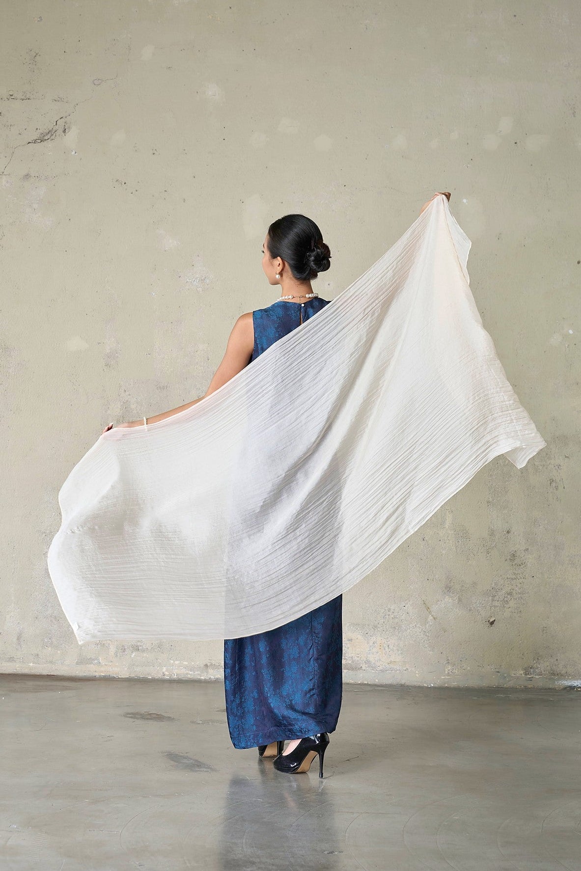 Champagne mulberry silk scarf caught in movement, held open behind the shoulders