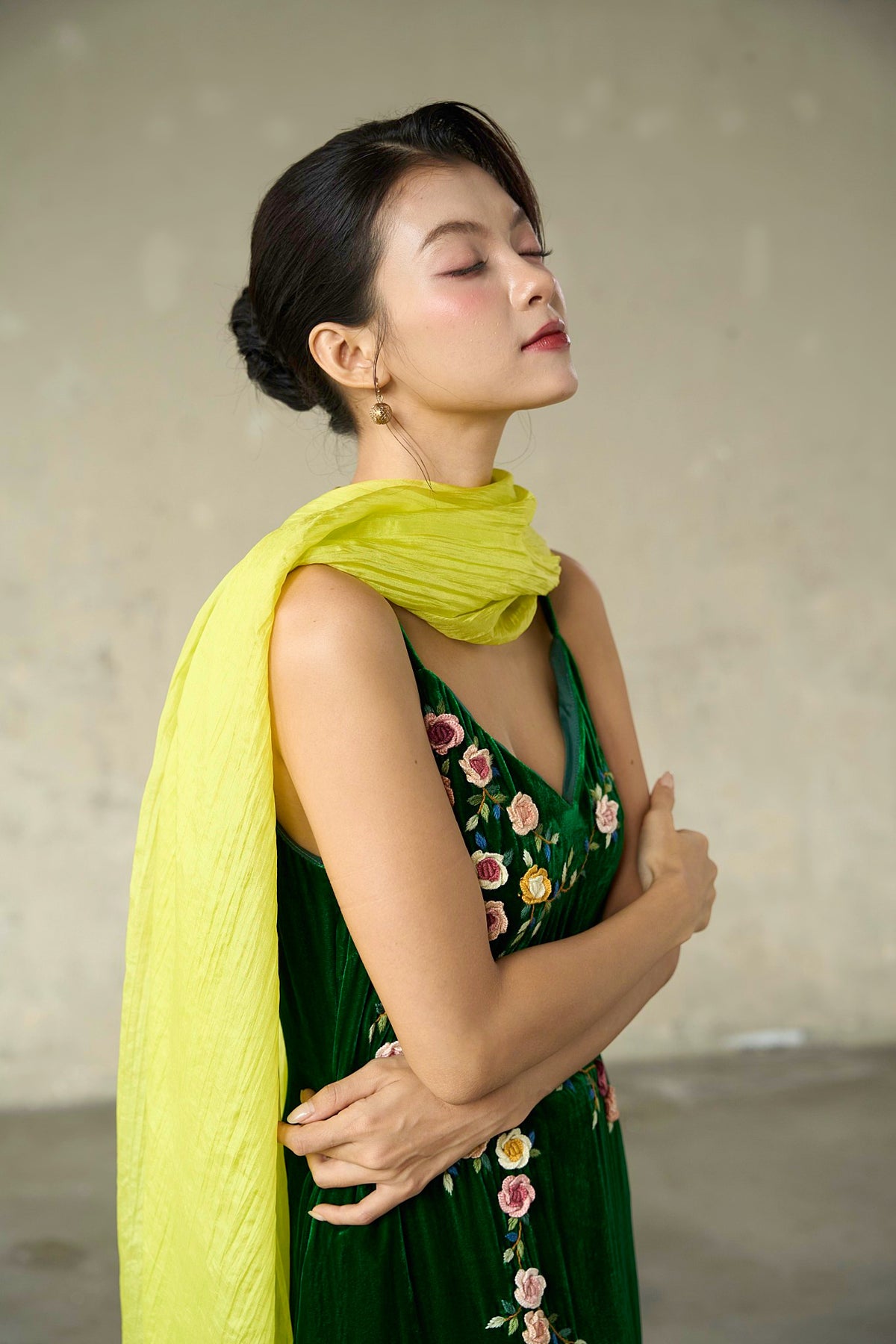 Editorial portrait of the citrine silk scarf knotted at the neck as an evening wrap
