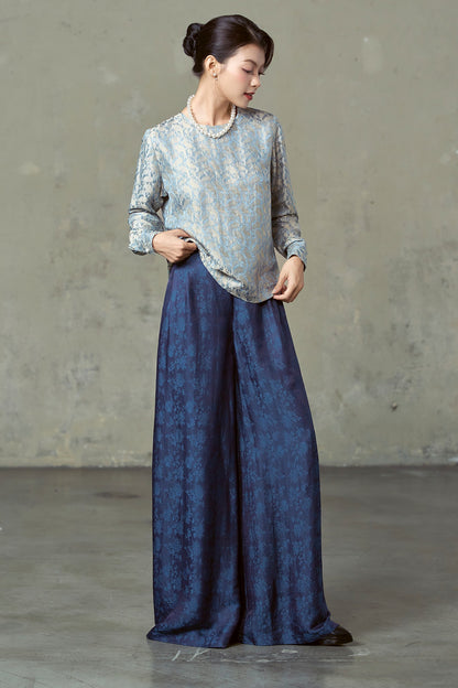 Navy silk wide-leg trousers moving at the hem, worn with blue paisley blouse