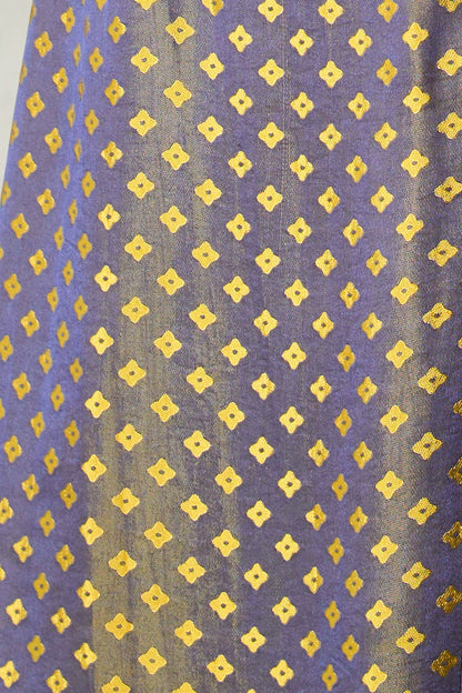 Close-up of Dusk Gold shot silk jacquard: slate blue-violet ground woven with small gold four-petal flowers