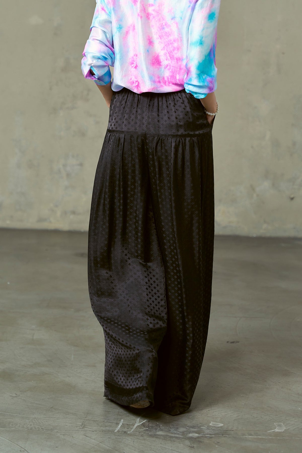 Black silk jacquard wide-leg trousers in movement, very full leg to the floor