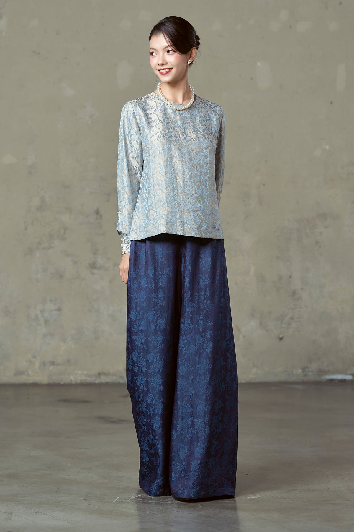 Three-quarter view of floor-length navy silk jacquard wide-leg trousers
