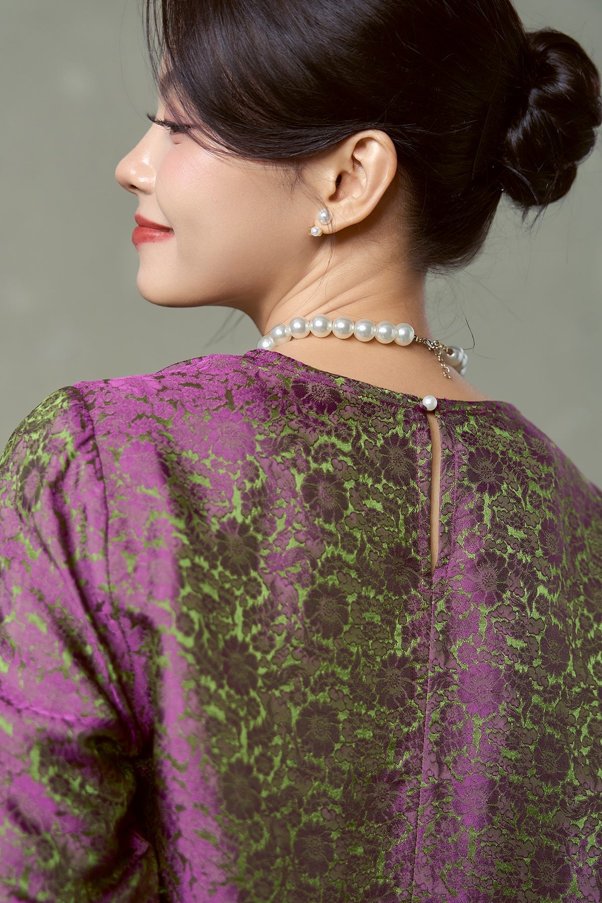 Keyhole opening and single button at the back neck of the Rosalind magenta olive silk blouse