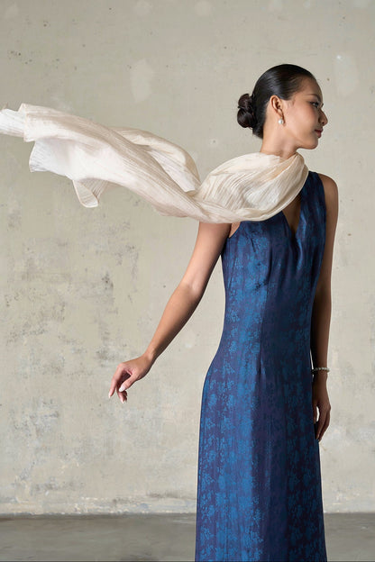 Champagne silk scarf looped at the neck and lifting in the air, showing the light crinkled texture