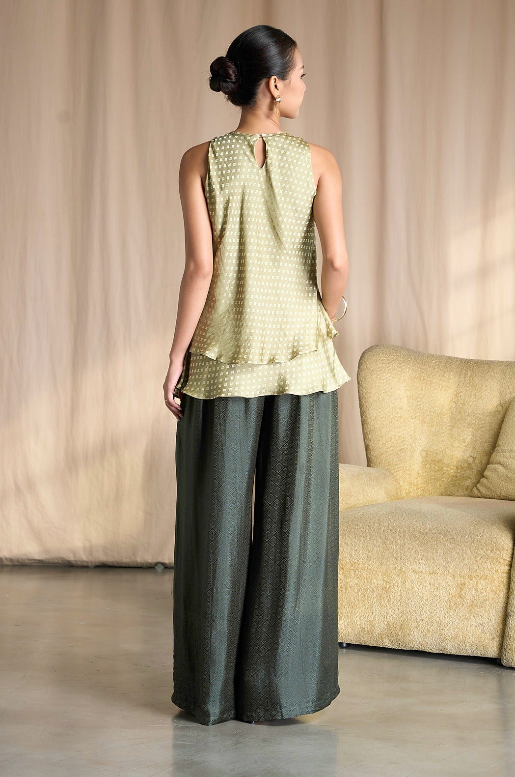 Back view of Portia Khaki Diamond silk wide-leg trousers styled with a sage tiered silk top
