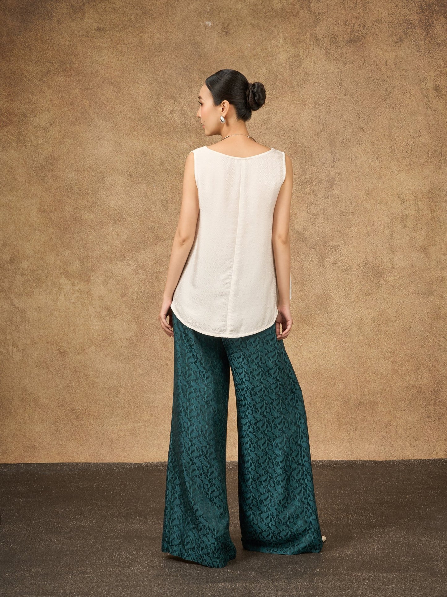 Model wearing the Ophelia teal dynasty silk palazzo trousers, three-quarter view