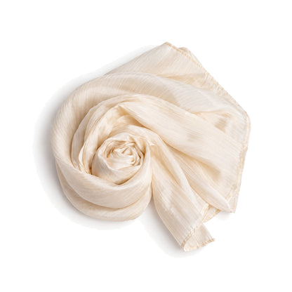 Pale champagne mulberry silk scarf coiled flat on a white background, showing the soft crinkled texture and rolled hem