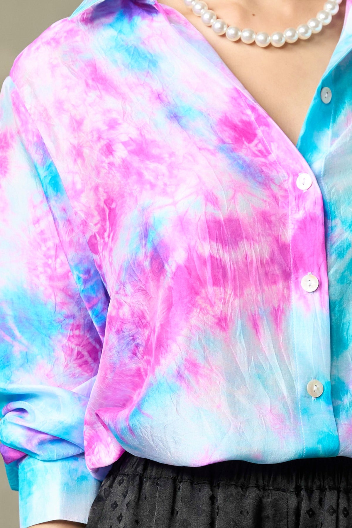 Close-up of hand tie-dyed habotai silk in fuchsia and turquoise with pearlescent buttons