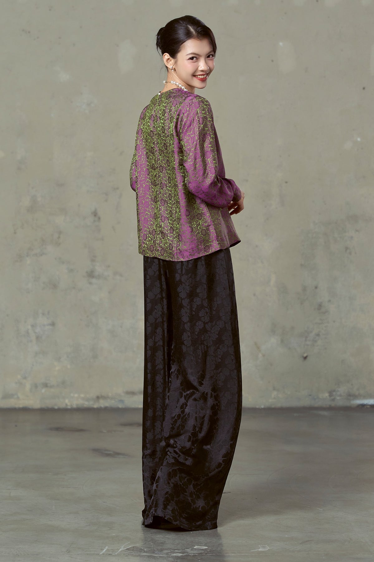 Back view of floor-length black floral silk jacquard wide-leg trousers