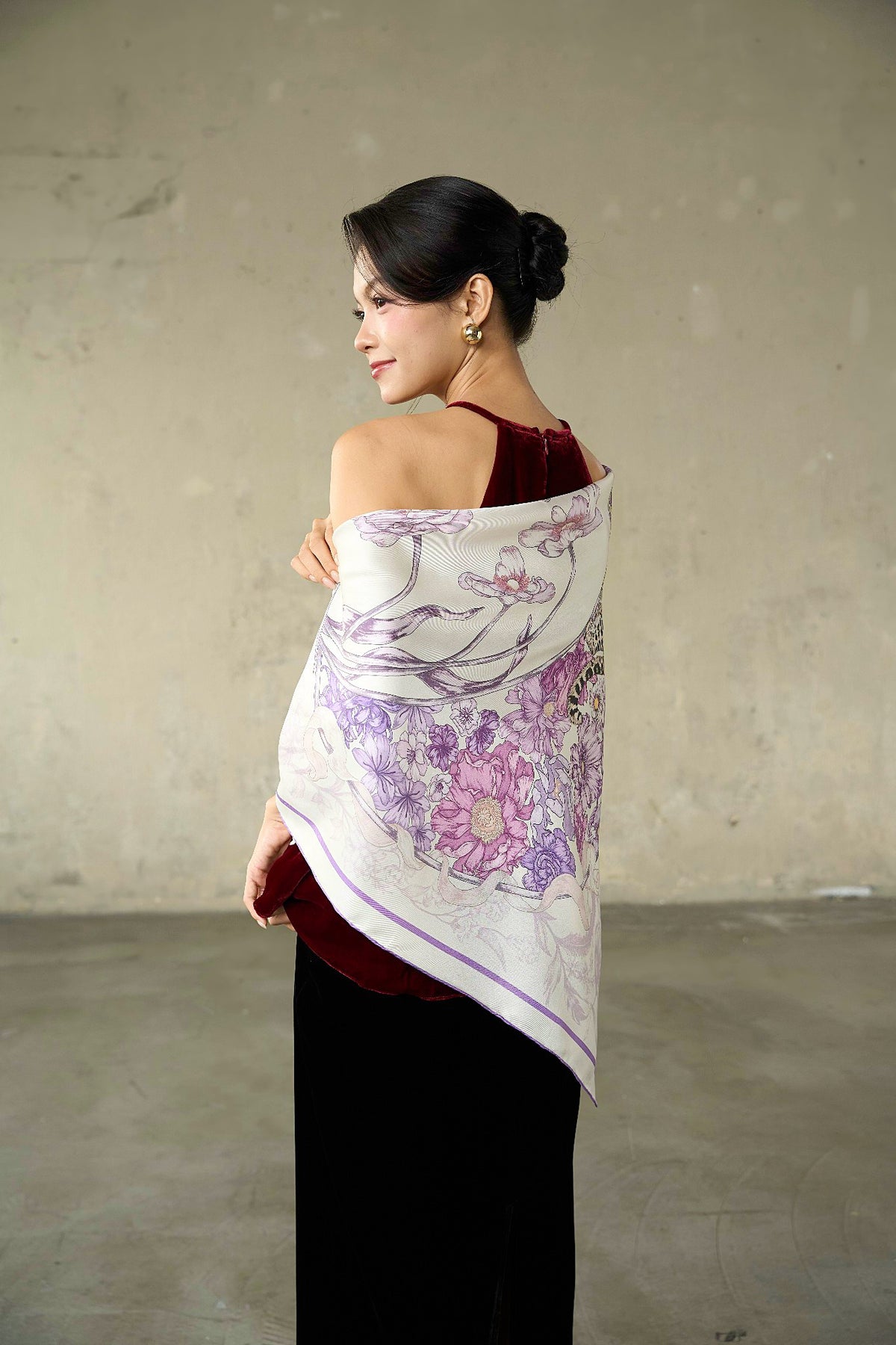 Model wearing the lilac leopard silk twill scarf as a shoulder wrap over a burgundy velvet top