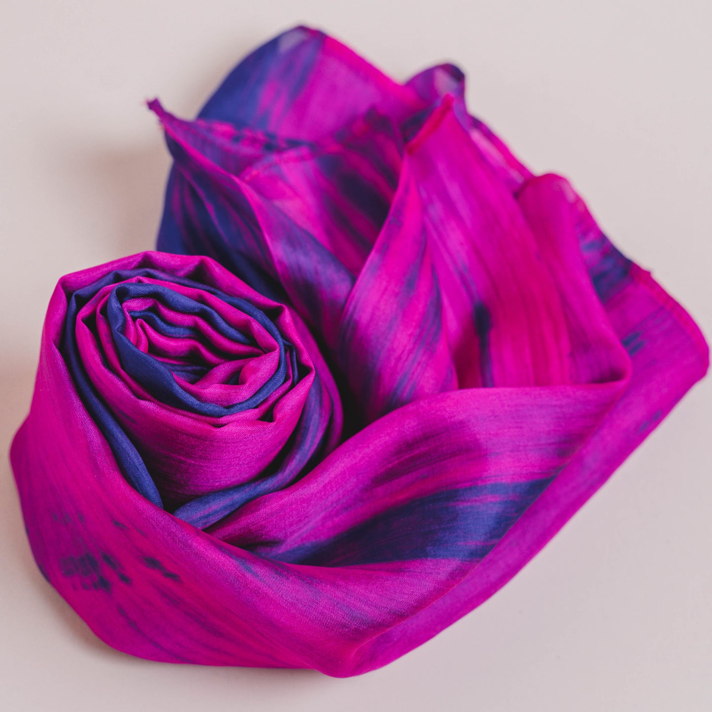 Fuchsia and blue mulberry silk scarf styled loosely around the neck