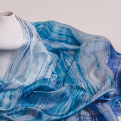 Sky blue brushstroke silk scarf held open to show the full design