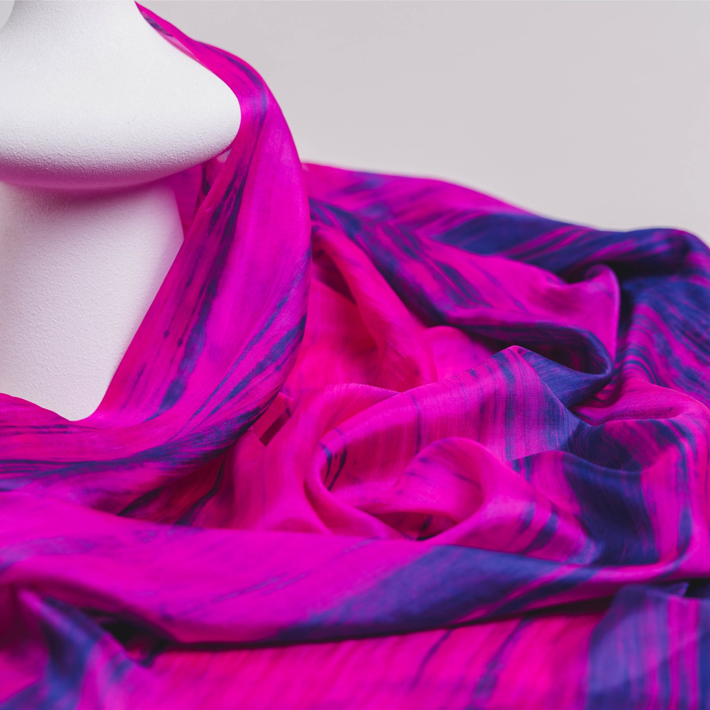 Close-up of the fuchsia and blue brushstroke silk scarf, showing hand-painted texture