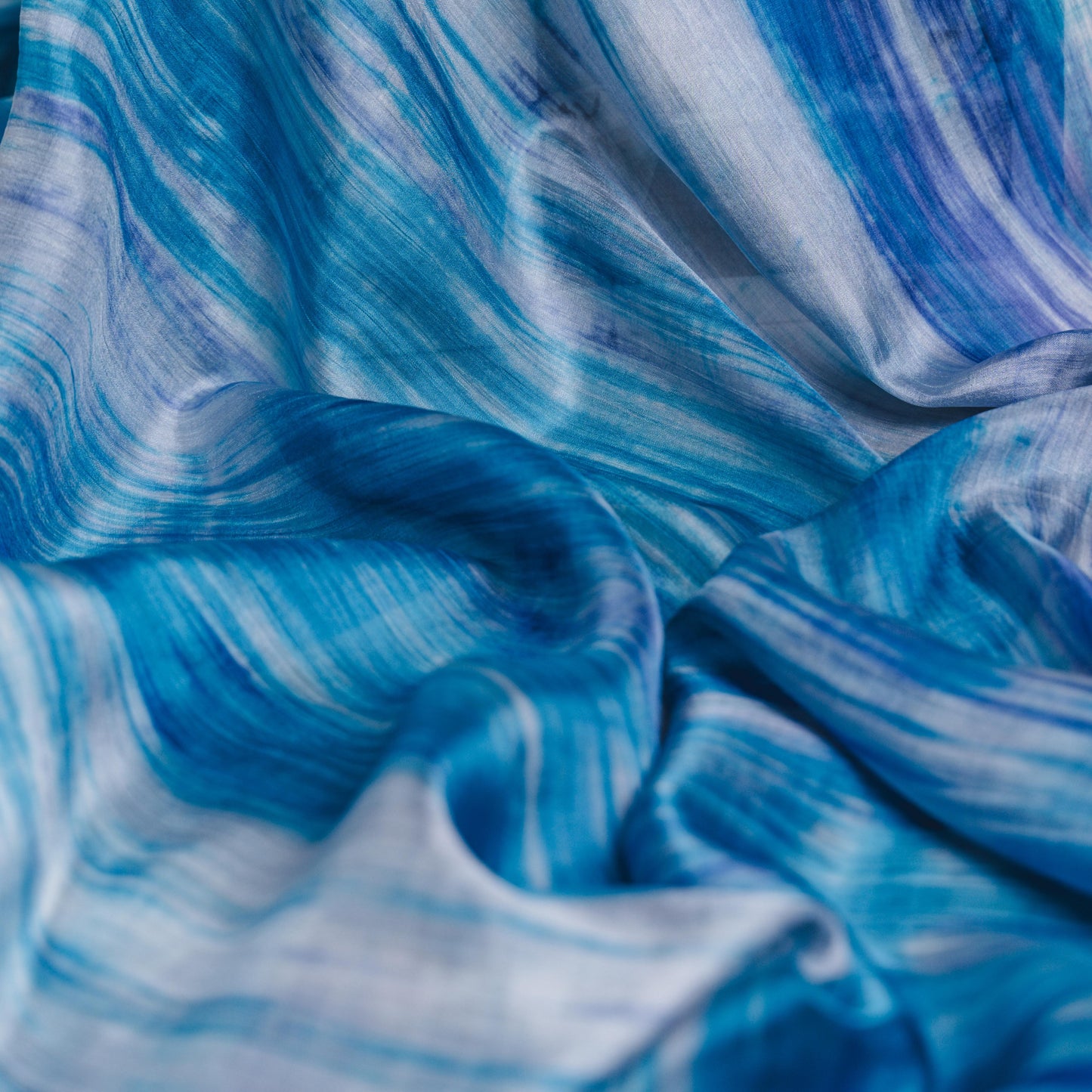 Close-up of the sky blue brushstroke silk scarf, showing hand-painted texture