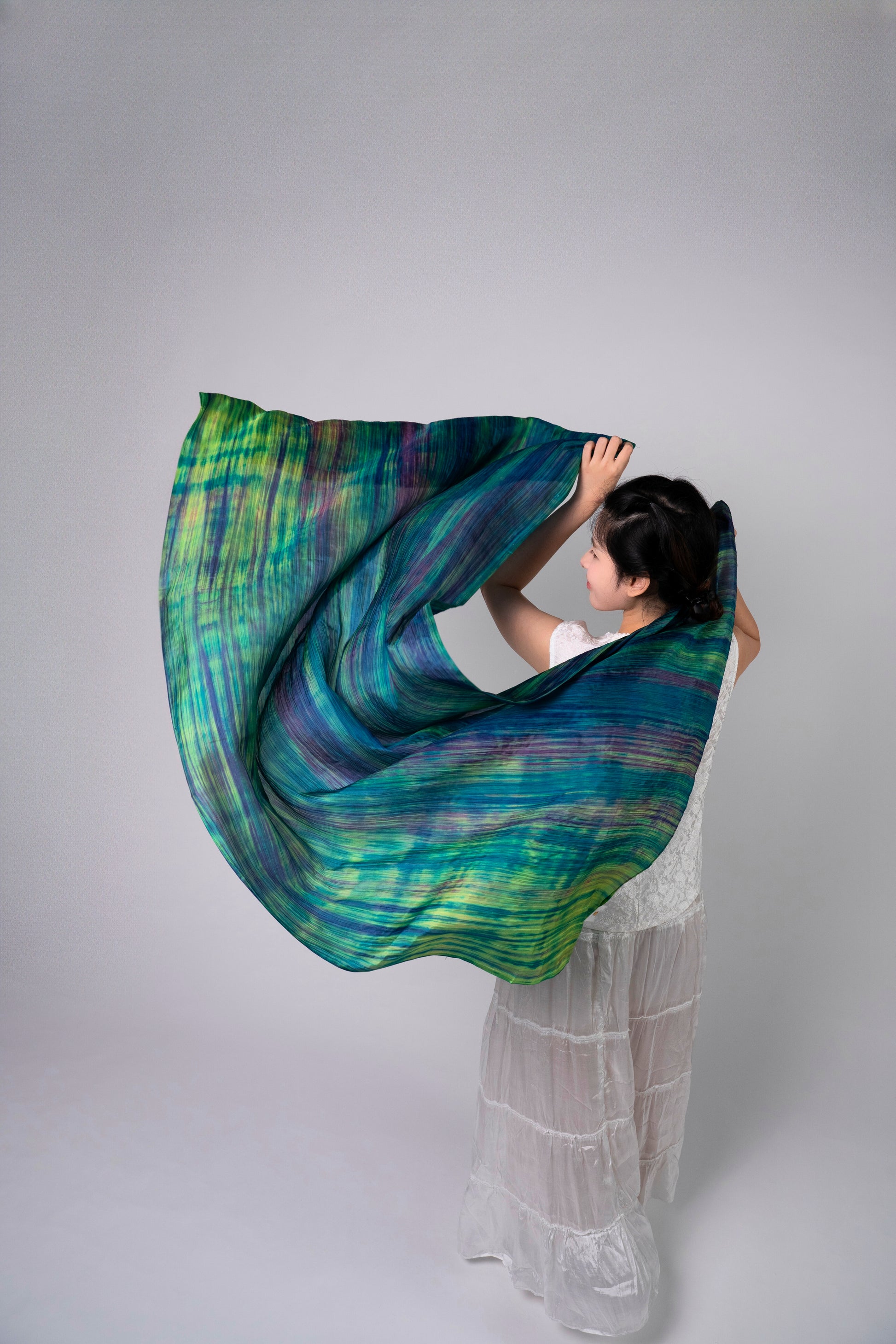Close-up of the emerald brushstroke silk scarf, showing hand-painted texture and lustre