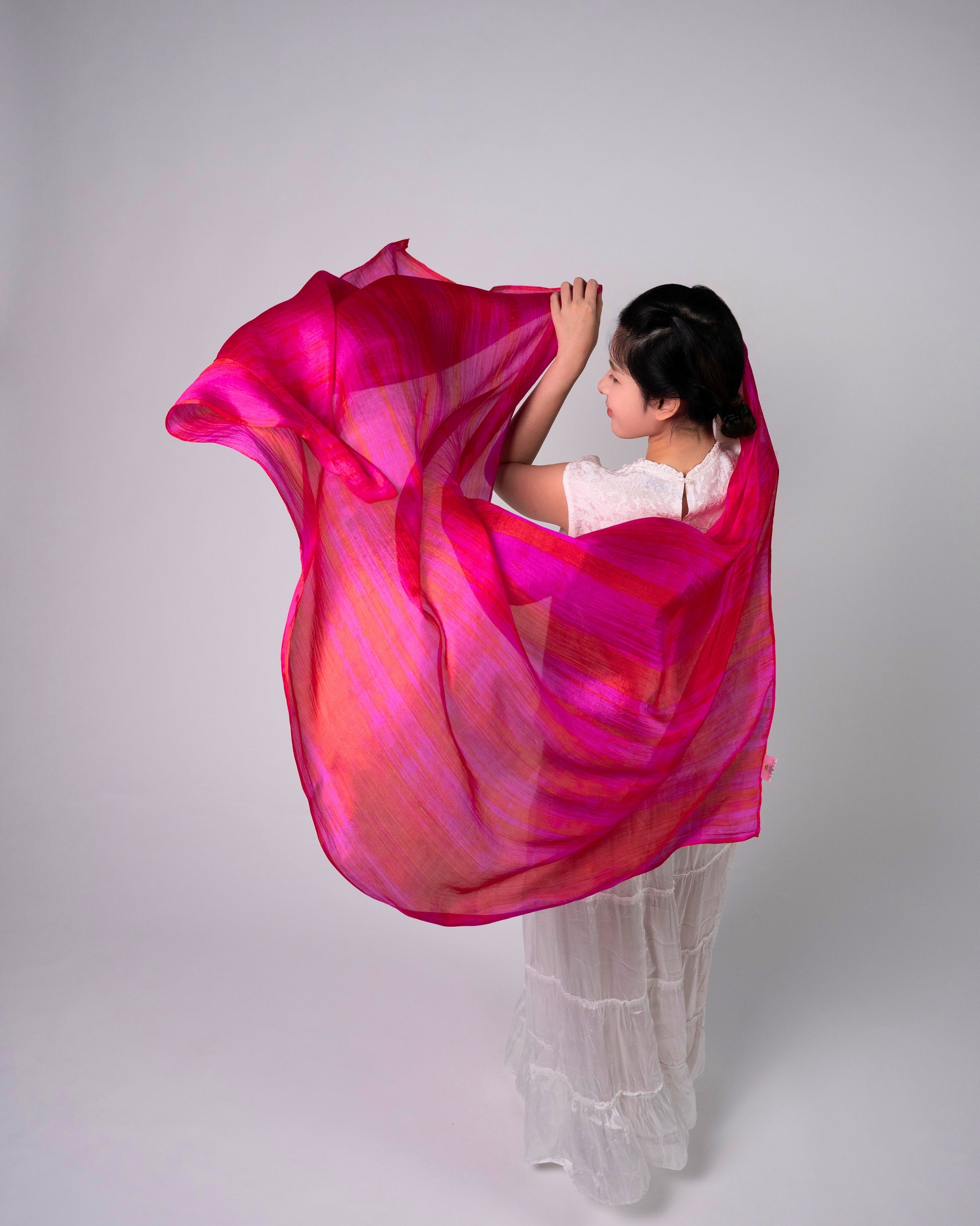 Hot pink brushstroke silk scarf worn as a flowing shawl, hand-dyed mulberry silk