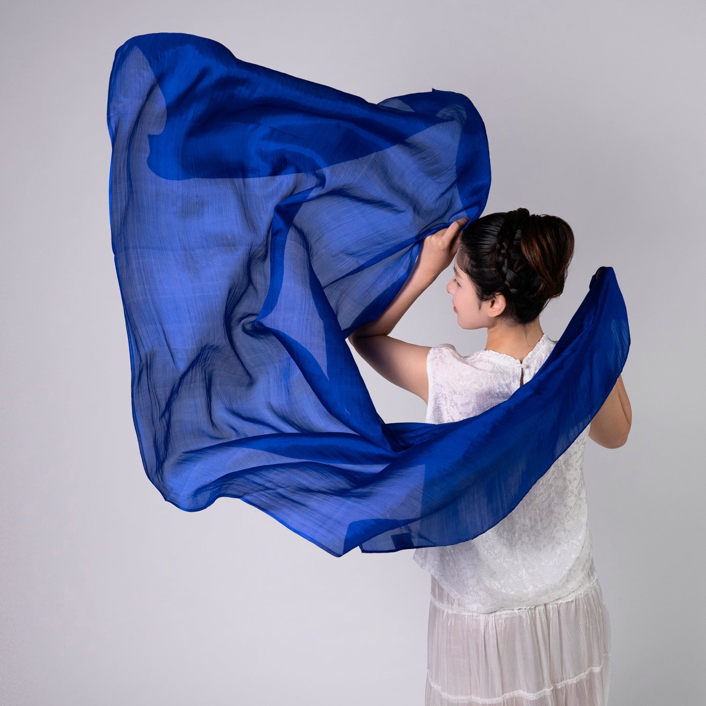 Model wearing a royal blue hand-dyed silk scarf draped over the shoulders