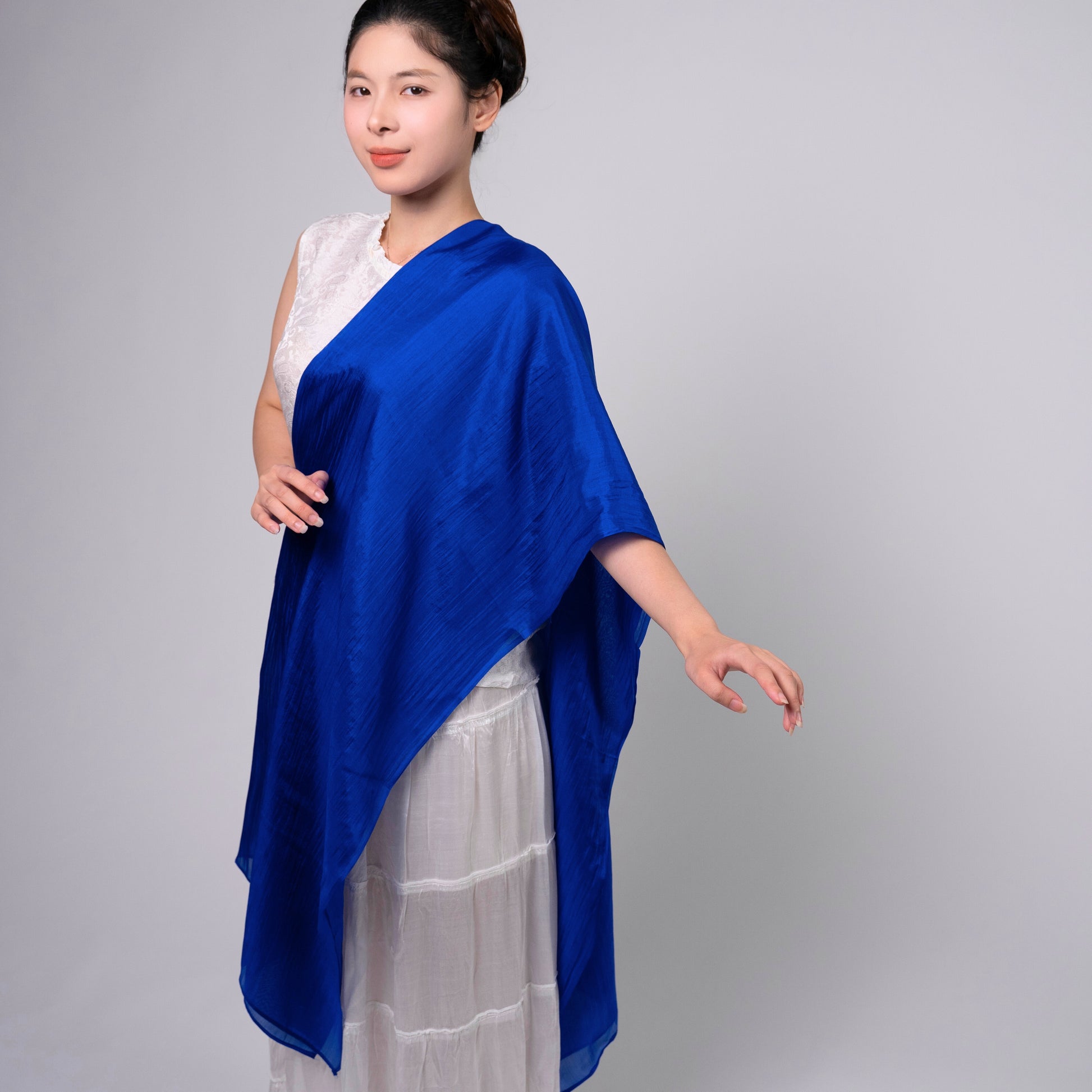 Royal blue mulberry silk scarf styled loosely around the neck, a lightweight wrap