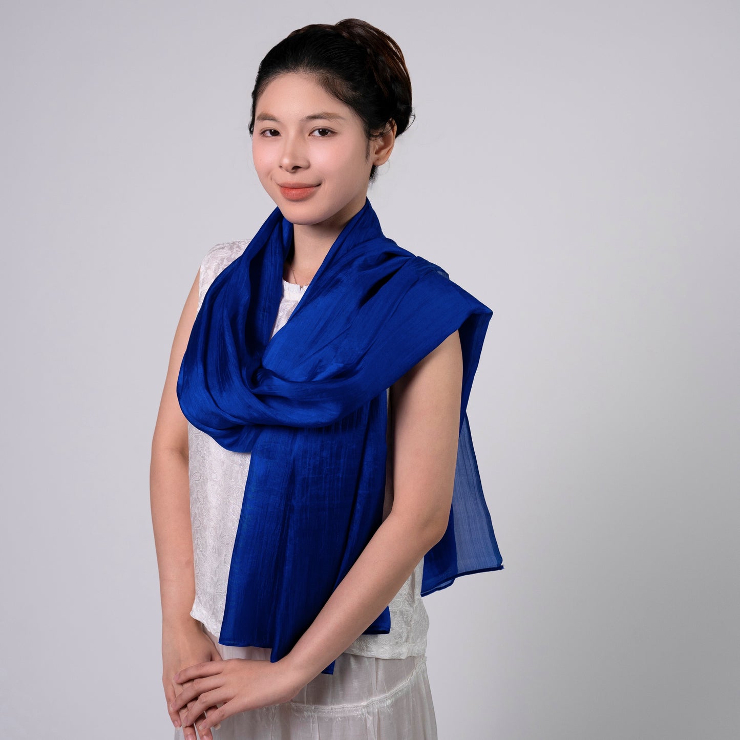Royal blue hand-dyed silk scarf held open to show the full rich colour