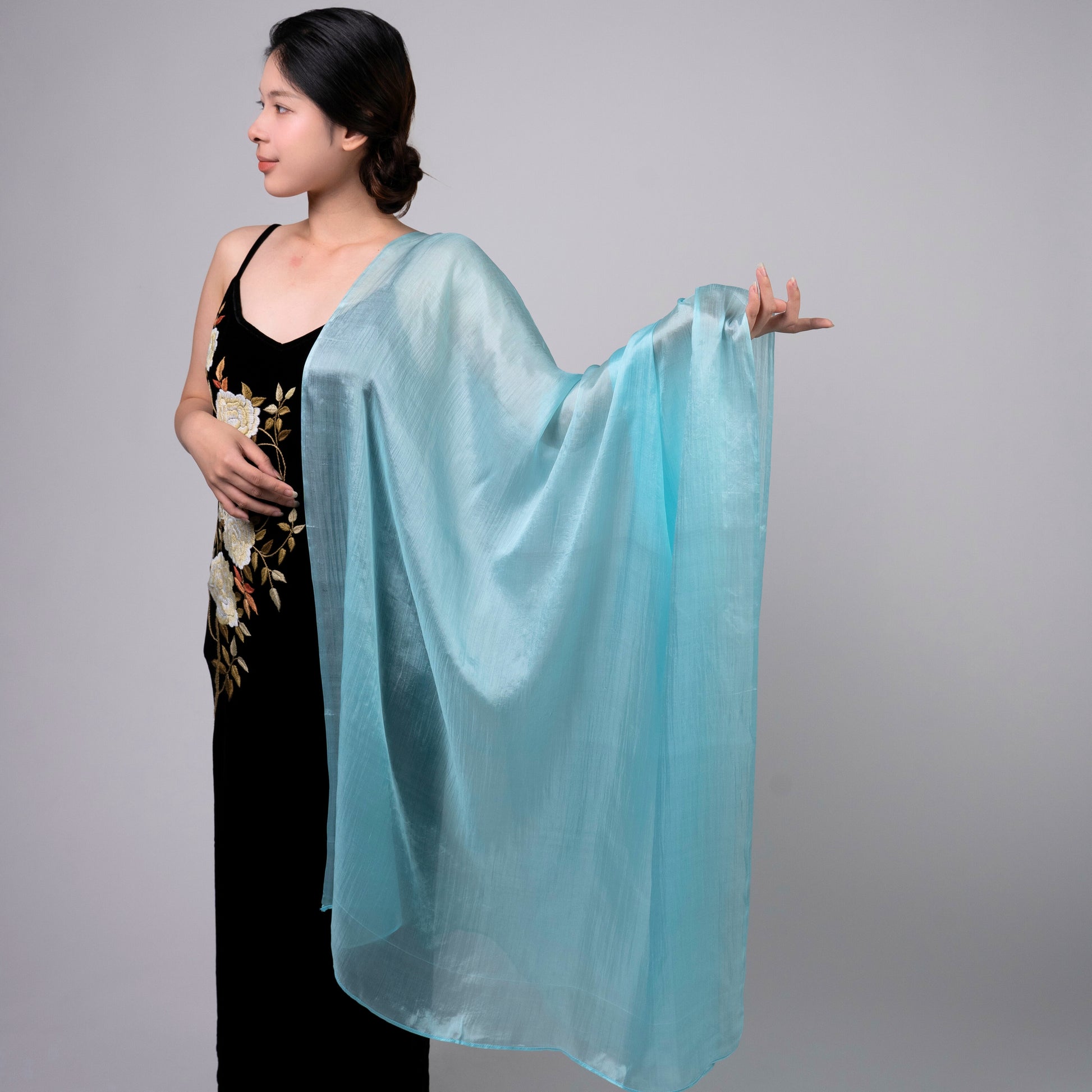 Ice blue mulberry silk scarf styled loosely around the neck, a lightweight wrap