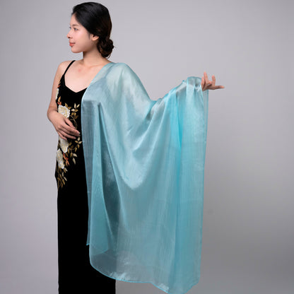 Ice blue mulberry silk scarf styled loosely around the neck, a lightweight wrap