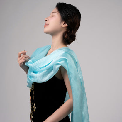 Model wearing an ice blue hand-dyed silk scarf draped over the shoulders