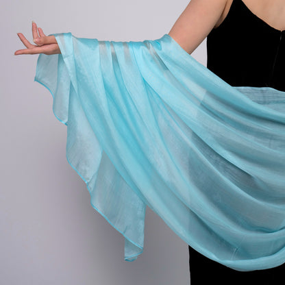 Ice blue silk scarf held open to show the full pale colour