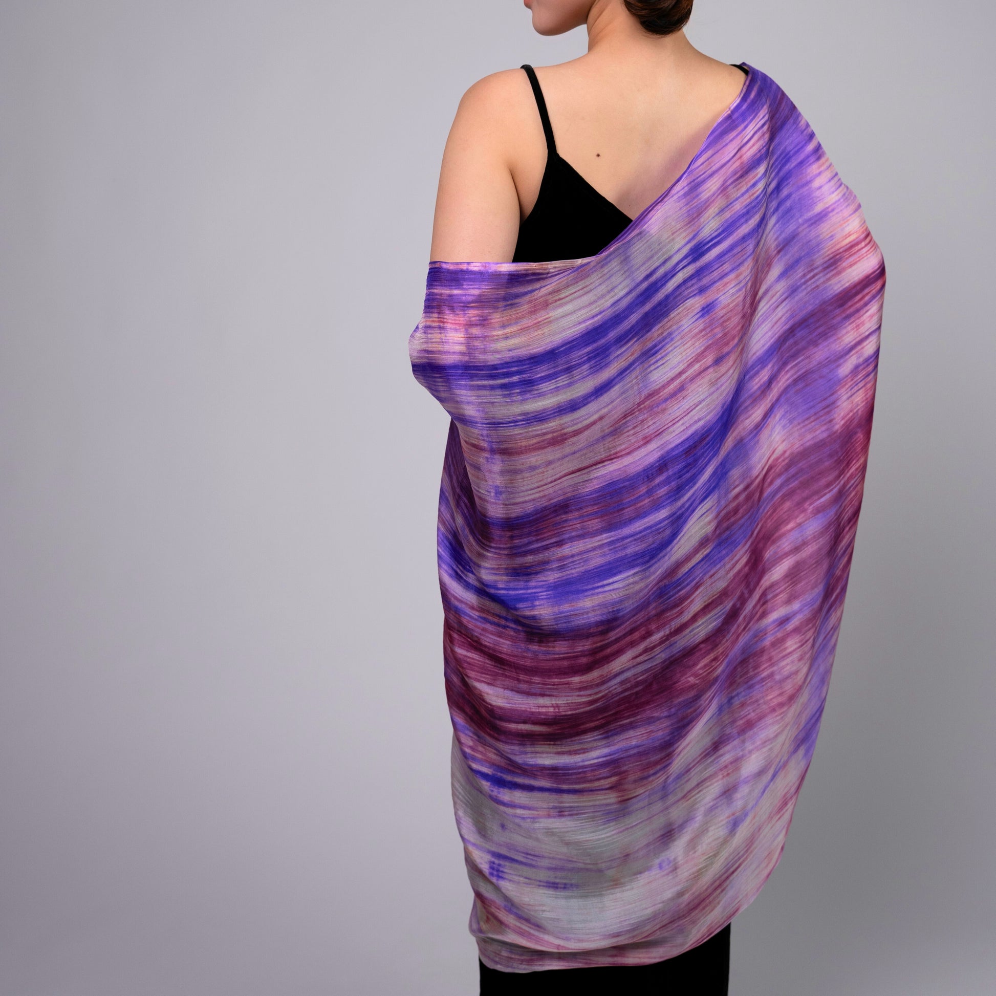 Back view of a model wearing the purple and pink brushstroke silk shawl by Silk & Bears