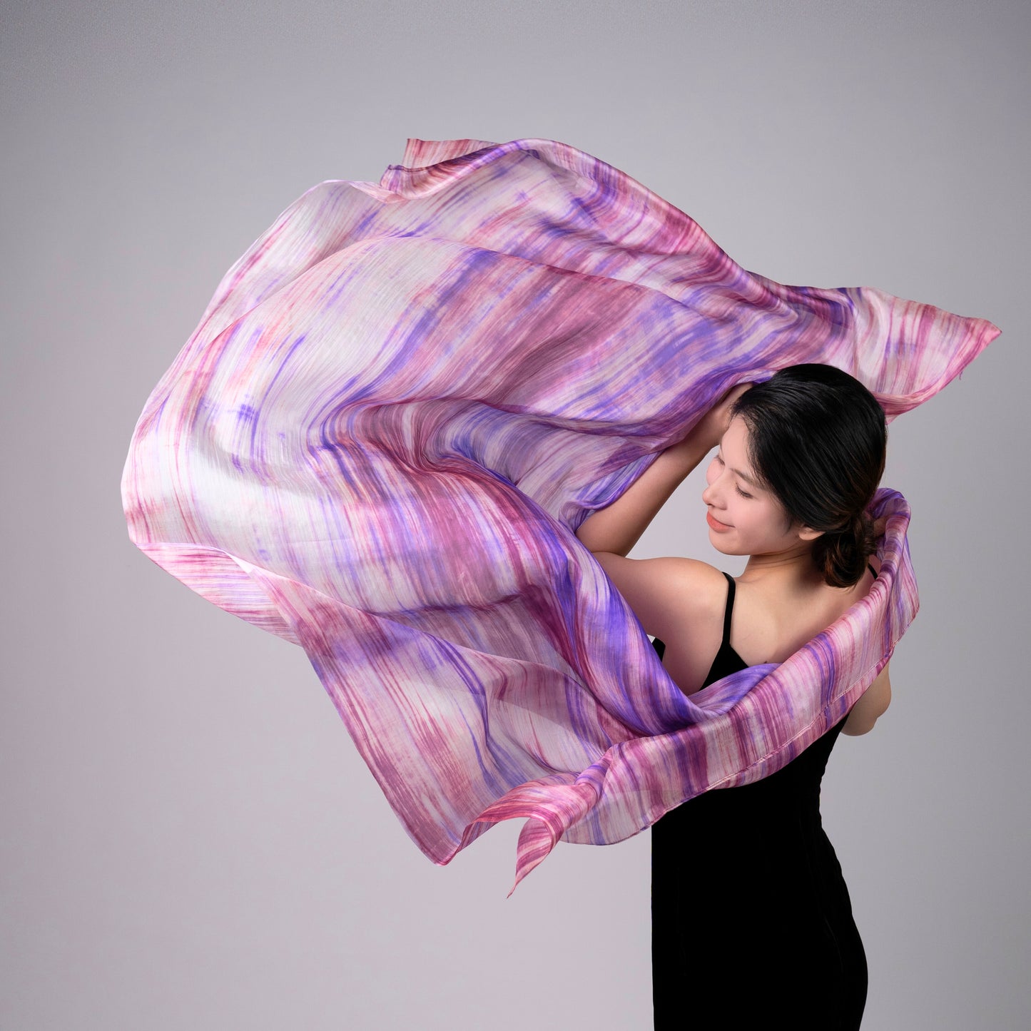 Model wearing a purple and pink brushstroke hand-dyed silk scarf draped over the shoulders