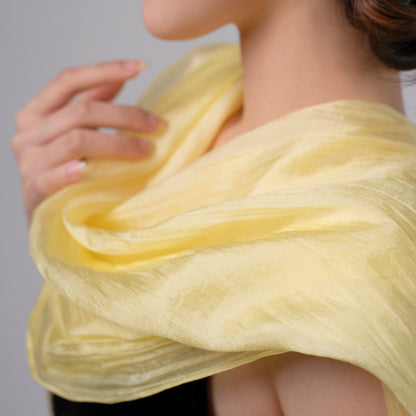 Model wearing a golden yellow hand-dyed silk scarf draped over the shoulders