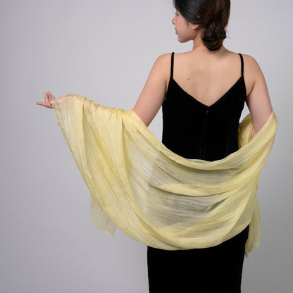 Golden yellow mulberry silk scarf styled loosely around the neck, a lightweight wrap