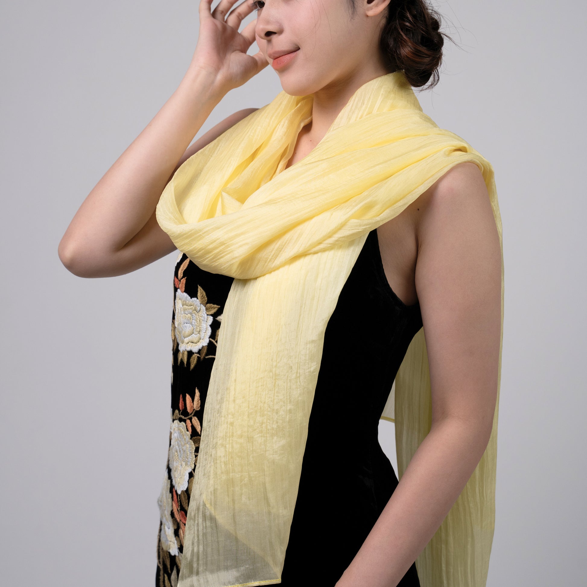 Close-up of the golden yellow hand-dyed silk scarf, showing texture and lustre