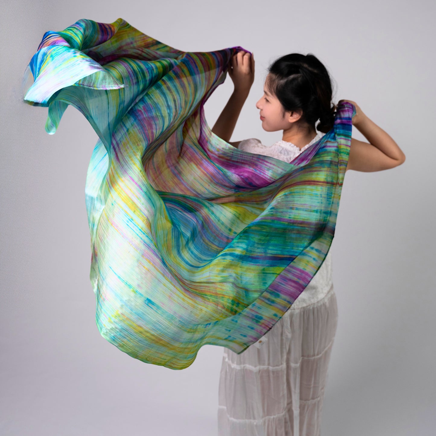 Rainbow brushstroke mulberry silk scarf styled loosely around the neck