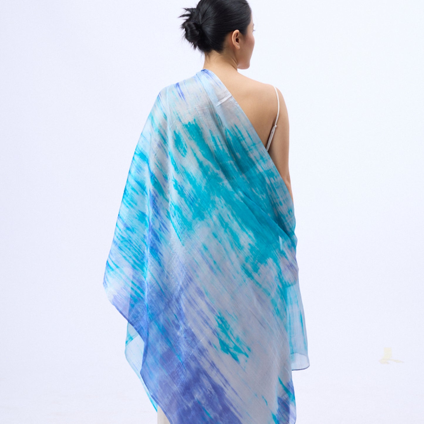 Model wearing a sky blue brushstroke hand-dyed silk scarf draped over the shoulders