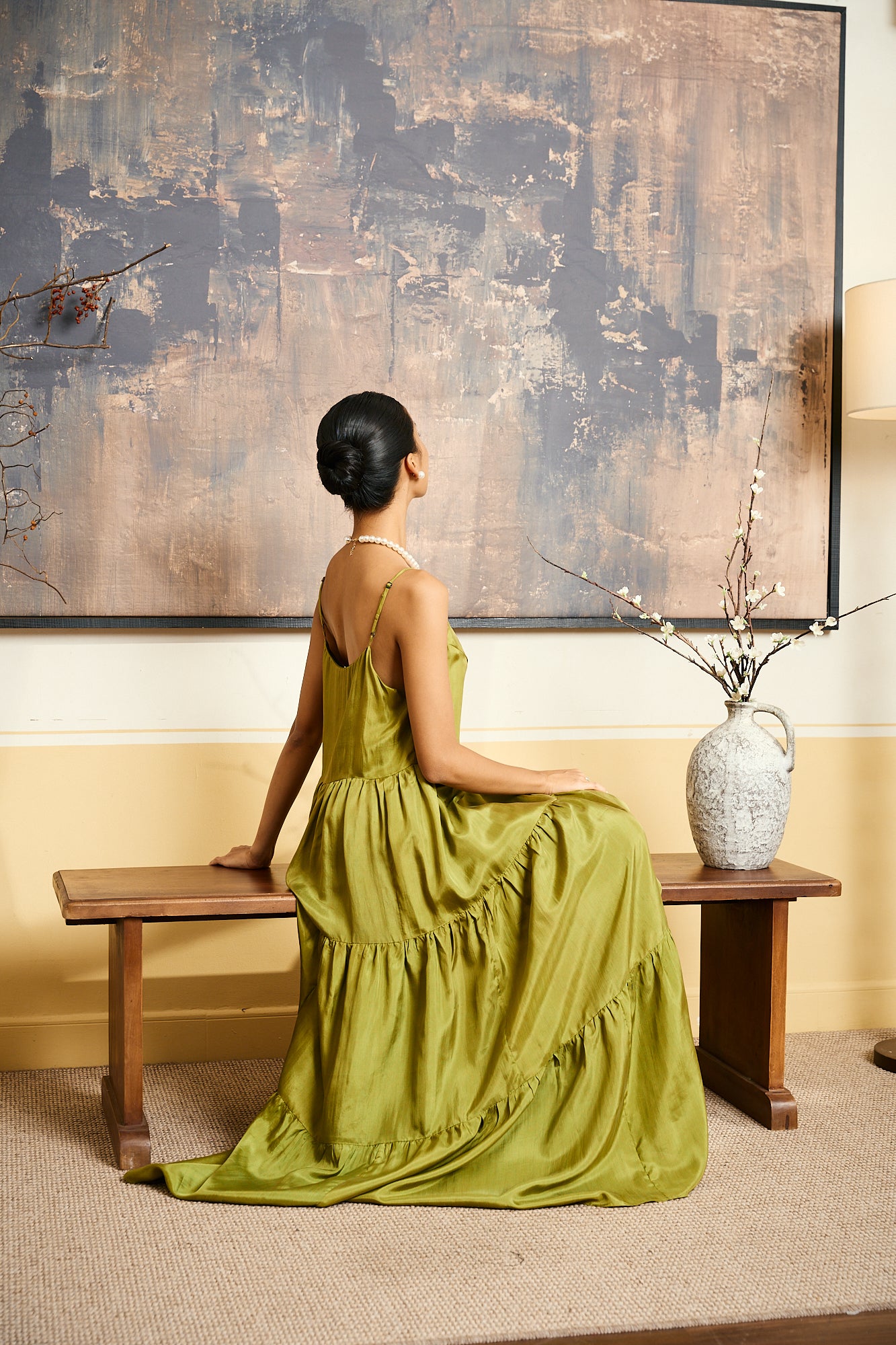Model wearing the Valentina olive gold silk tiered maxi dress, three-quarter view