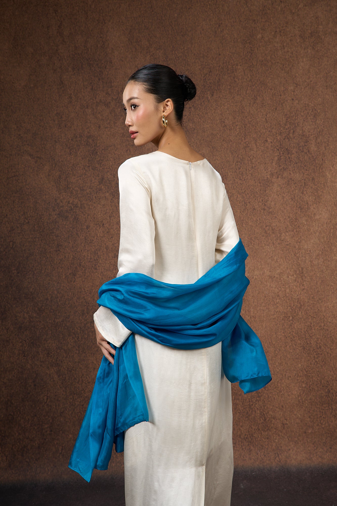 Teal blue silk scarf held open to show the full colour